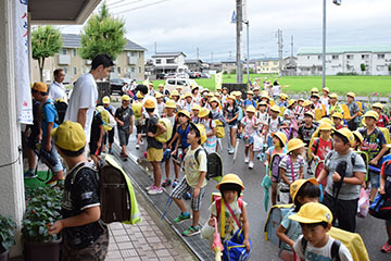 「玄関前に集まった大勢の児童は佐藤選手にびっくり」の画像