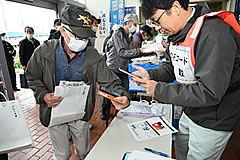 「バスによる避難の集合場所での避難者受付の様子」の画像