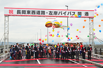 「関係者がお祝いのテープカットとくす玉割り」の画像