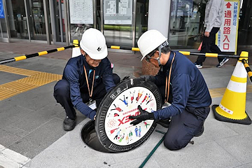 「企業広告をデザインしたマンホールふた」の画像